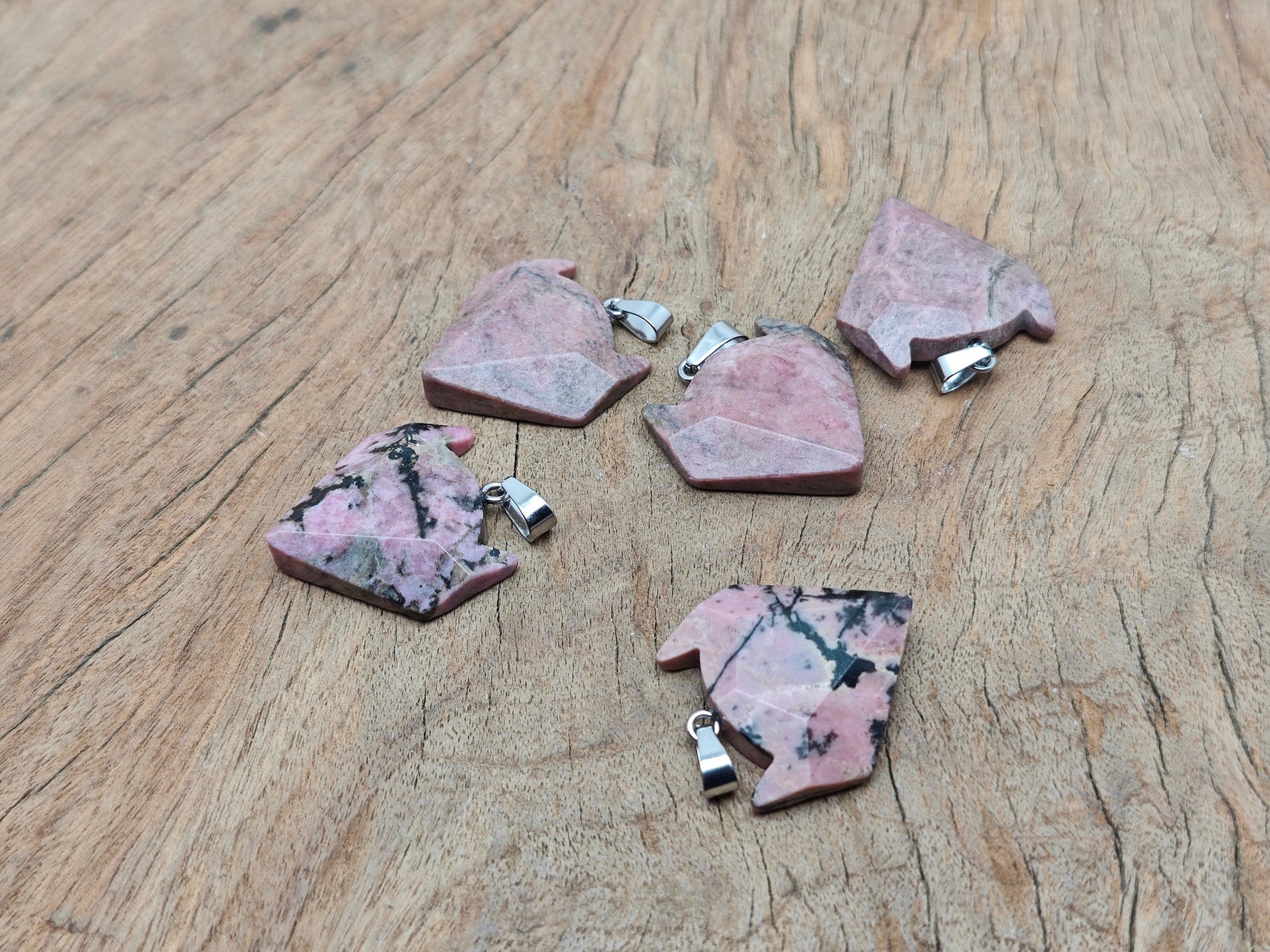 Rhodonite wolf head gemstone pendant from GemstoneGO, featuring a polished crystal jewelry piece with intricate wolf design.
