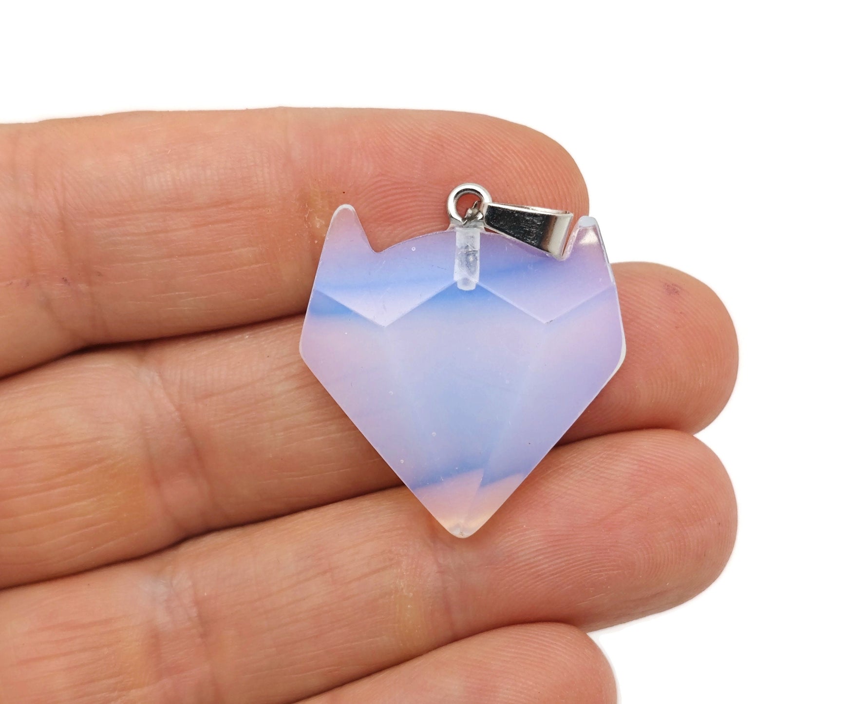 Opalite wolf head gemstone pendant from GemstoneGO, featuring a detailed wolf design with glowing opalite stone in a jewelry display.