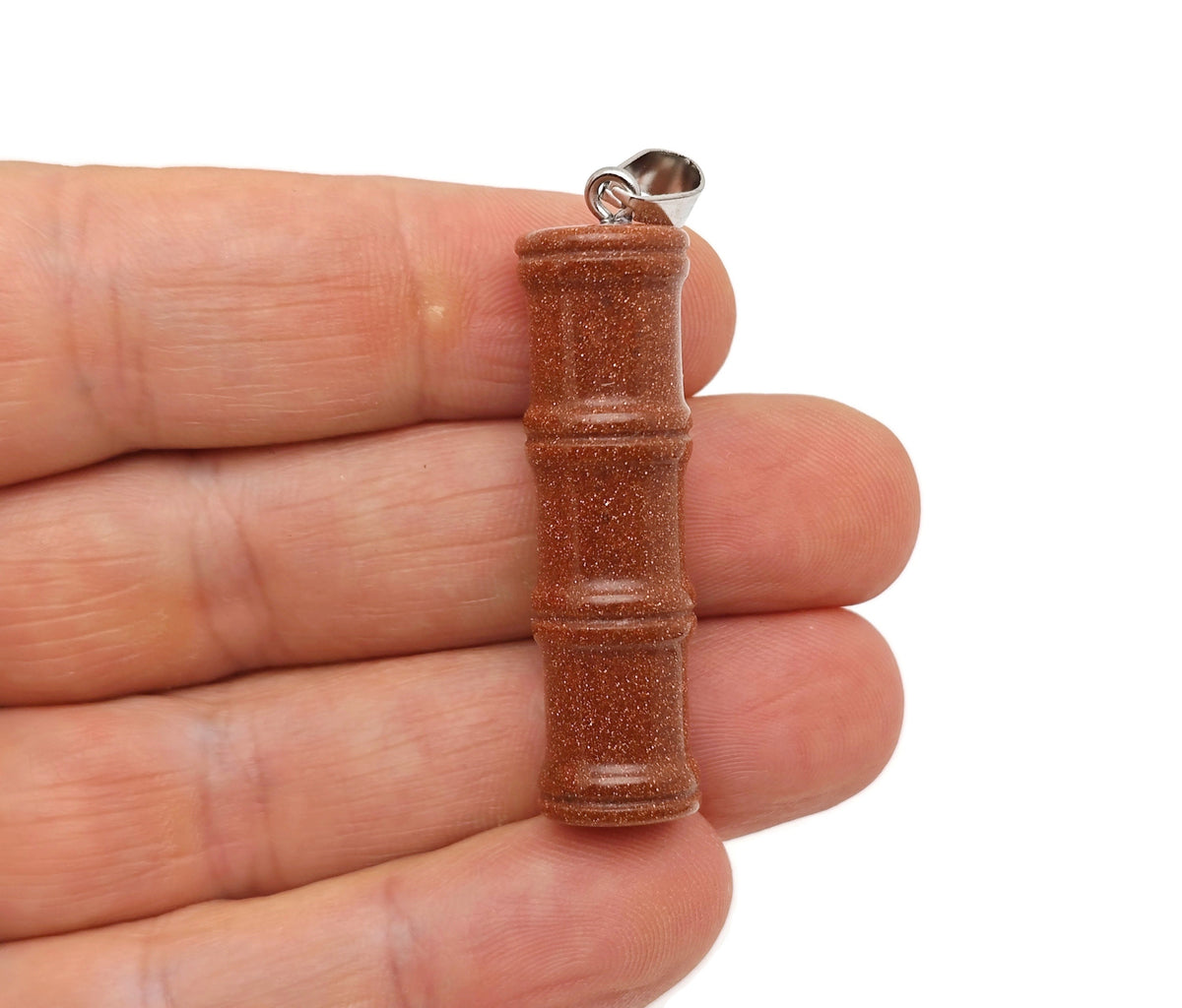 Goldstone bamboo-shaped crystal pendant with protective crystal by GemstoneGO, showcasing a polished gold-colored crystal design.