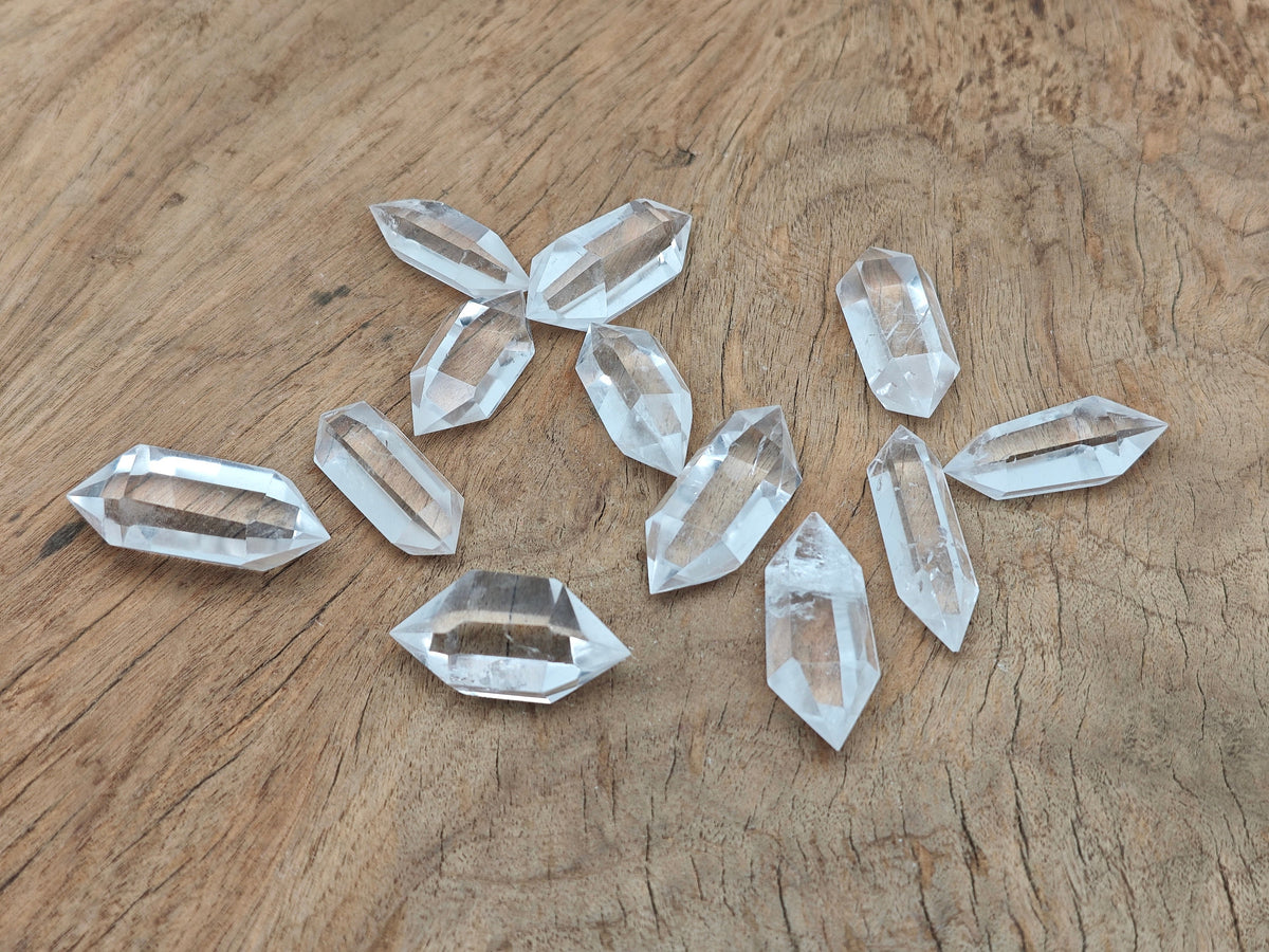 Clear Quartz double obelisk crystal tower by GemstoneGO, showing a polished transparent gemstone with natural facets and pointed tips.