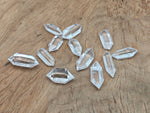 Clear Quartz double obelisk crystal tower by GemstoneGO, showing a polished transparent gemstone with natural facets and pointed tips.