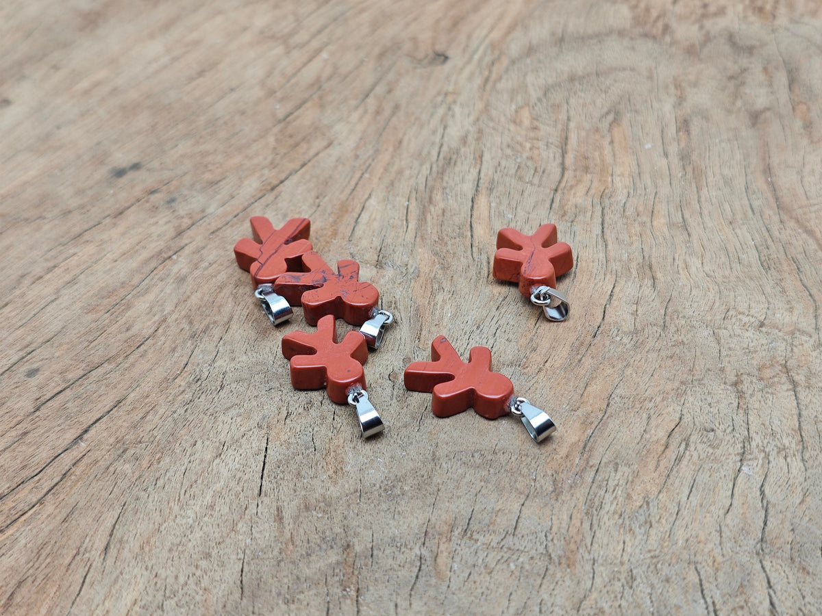 Red Jasper gingerbread cookie men crystal pendant from GemstoneGO, featuring detailed gingerbread shapes and vibrant red jasper mineral specimen.