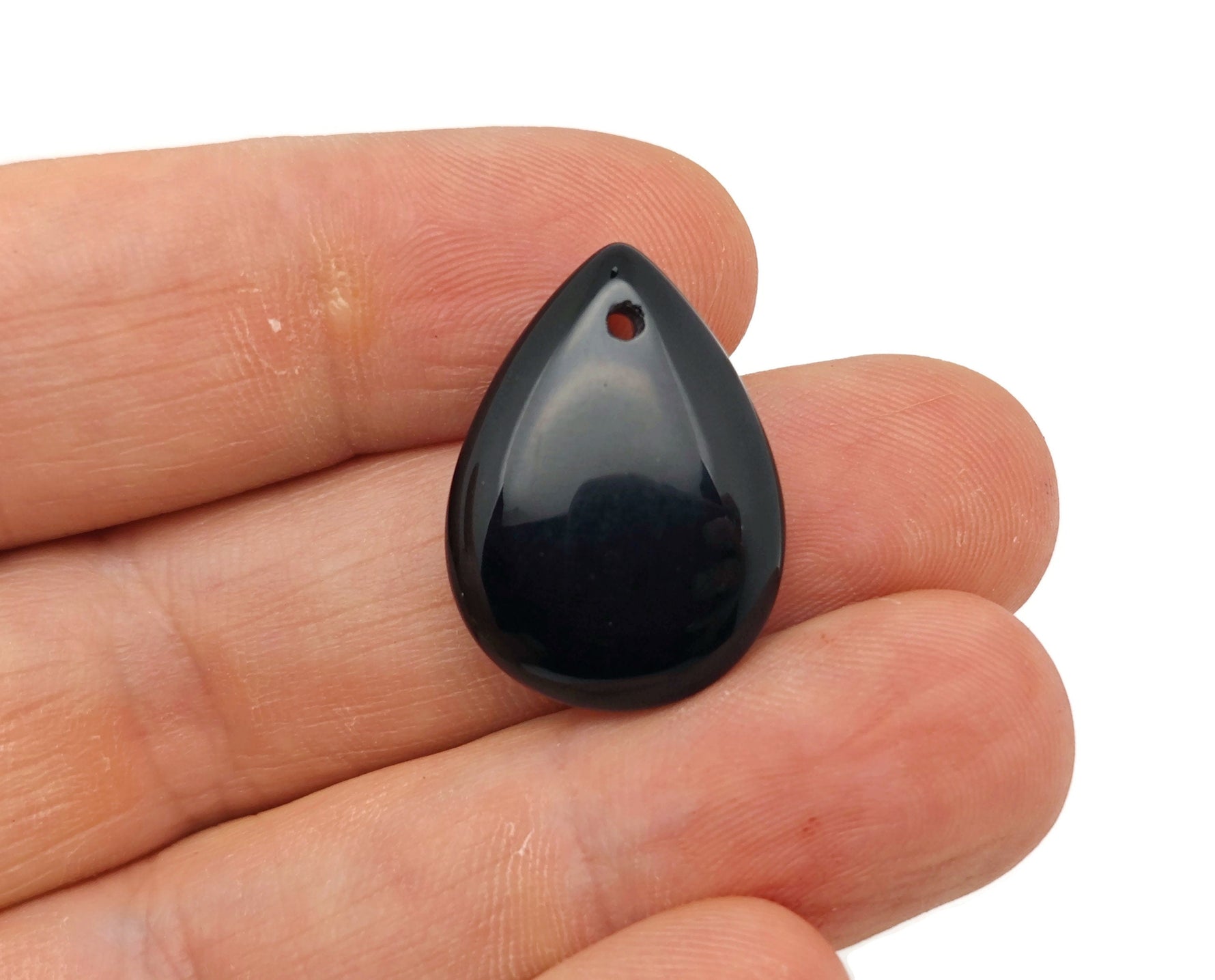 Dainty obsidian drop crystal pendant for DIY jewelry making, featuring a black gemstone with silver setting, shown close-up.