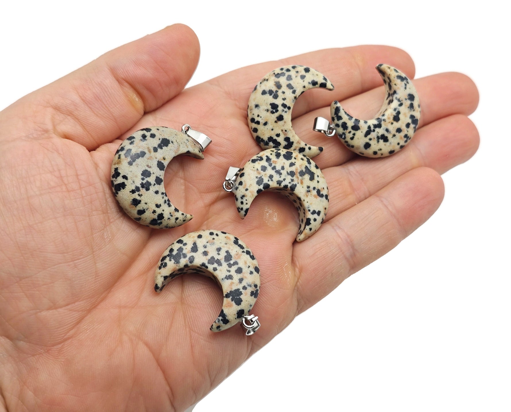 Dalmatian Jasper moon gemstone pendant featuring a crescent moon shape from GemstoneGO, showcasing black spots on a cream background.
