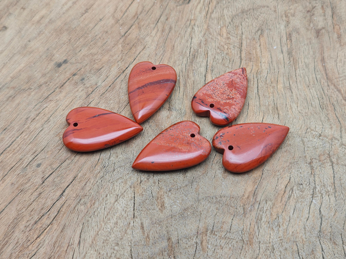 Red Jasper heart-shaped love crystal pendant with a polished finish, showcasing vibrant red hues and a smooth, rounded design.