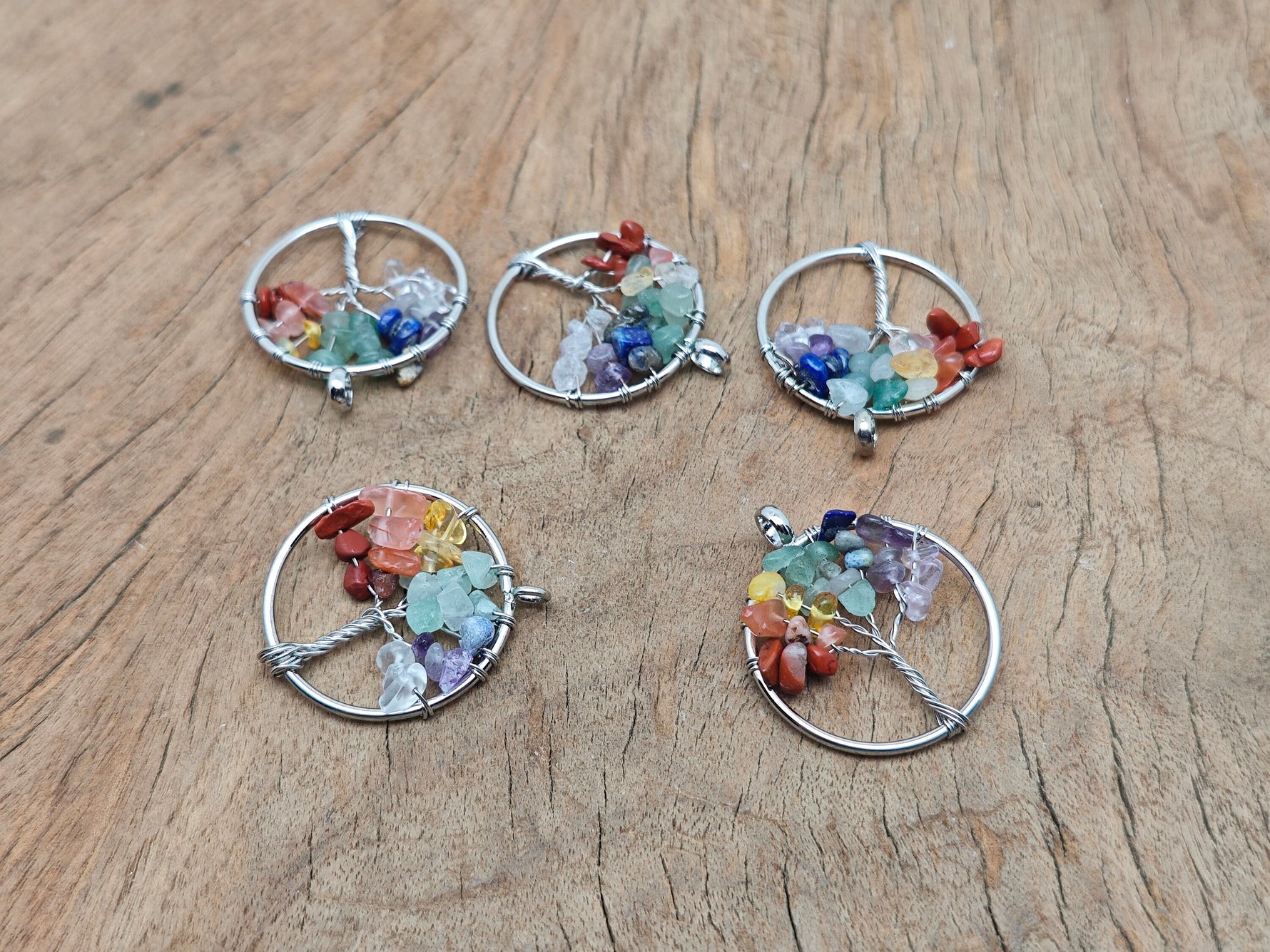 Seven chakra tree of life gemstone pendant with colorful stones and intricate metalwork, designed for spiritual jewelry.