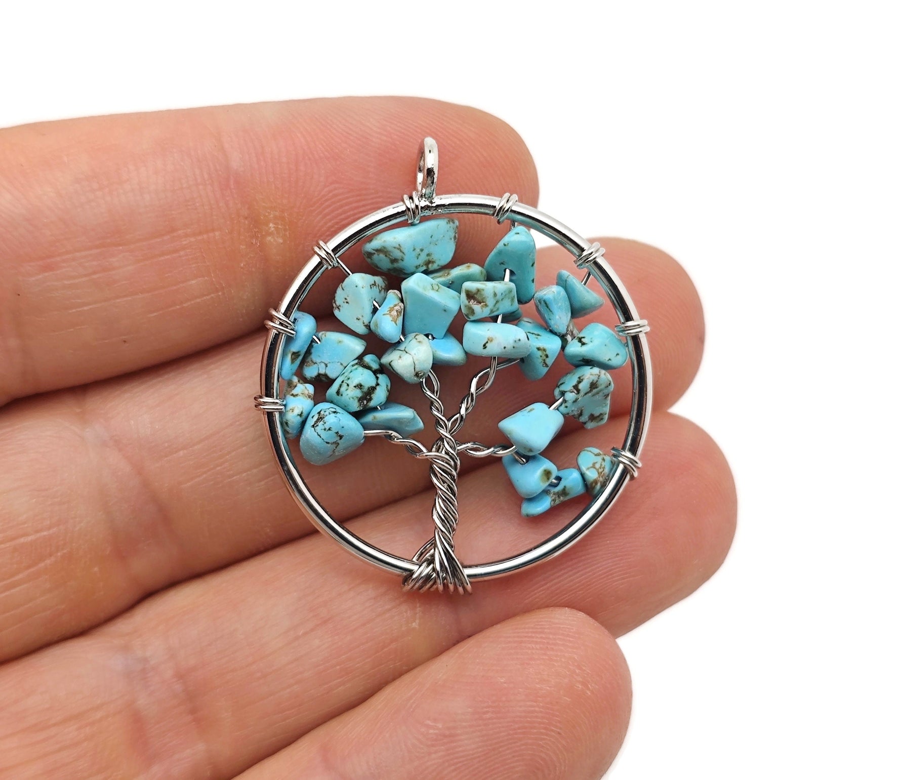 Turquoise Tree of Life gemstone pendant with intricate wire wrapping, displayed on a neutral background.
