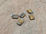 Tiger Eye rectangle-shaped crystal pendant from GemstoneGO, showcasing a polished gemstone with natural gold and brown tones.