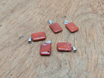 Red Jasper rectangle-shaped crystal pendant by GemstoneGO, showcasing a vibrant red gemstone with a polished rectangular design.