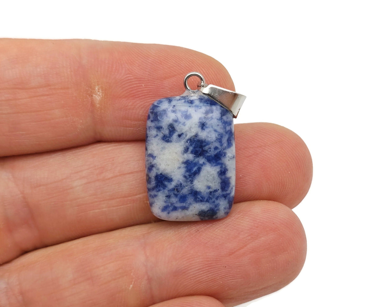 Sodalite rectangle-shaped crystal pendant from GemstoneGO, showcasing deep blue and white mineral patterns on a jewelry display.