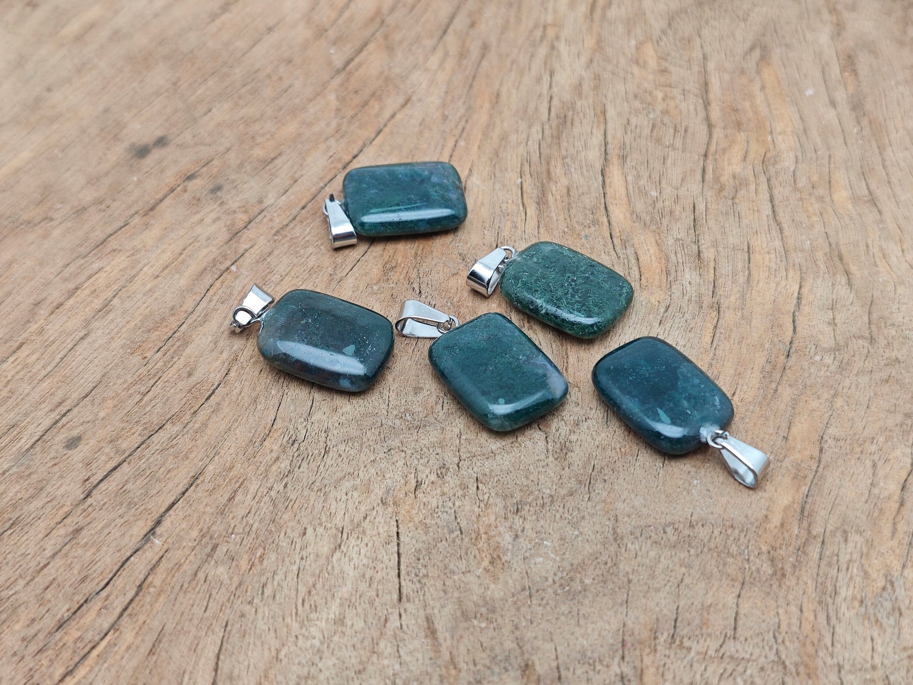 Moss agate crystal pendant in a rectangular shape with natural green and brown patterns, from GemstoneGO.