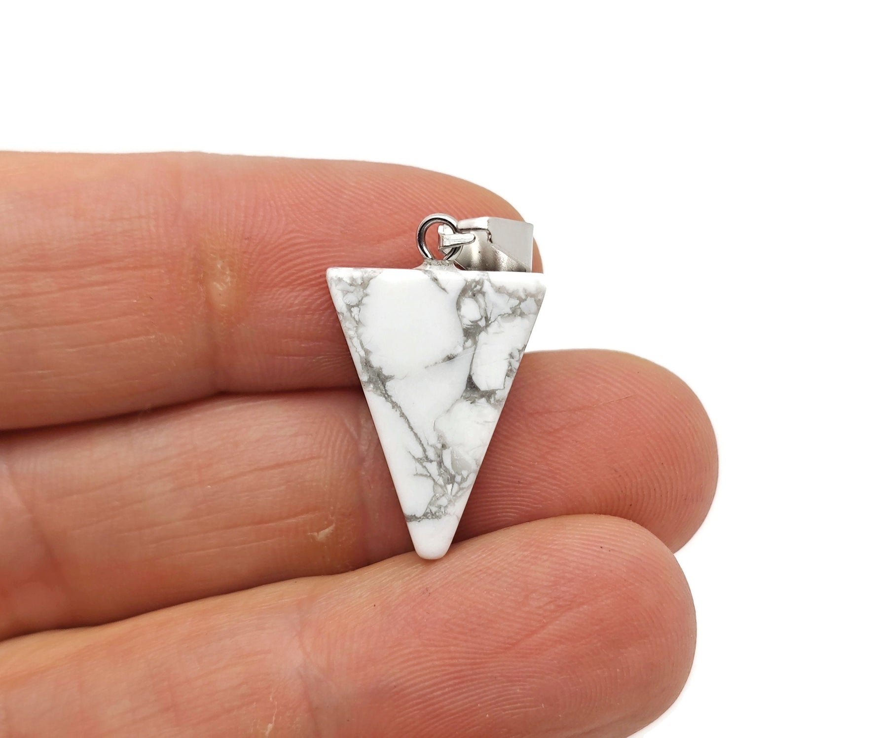 Howlite triangle-shaped crystal pendant by GemstoneGO, showcasing smooth white gemstone with gray veining, ideal for jewelry making.