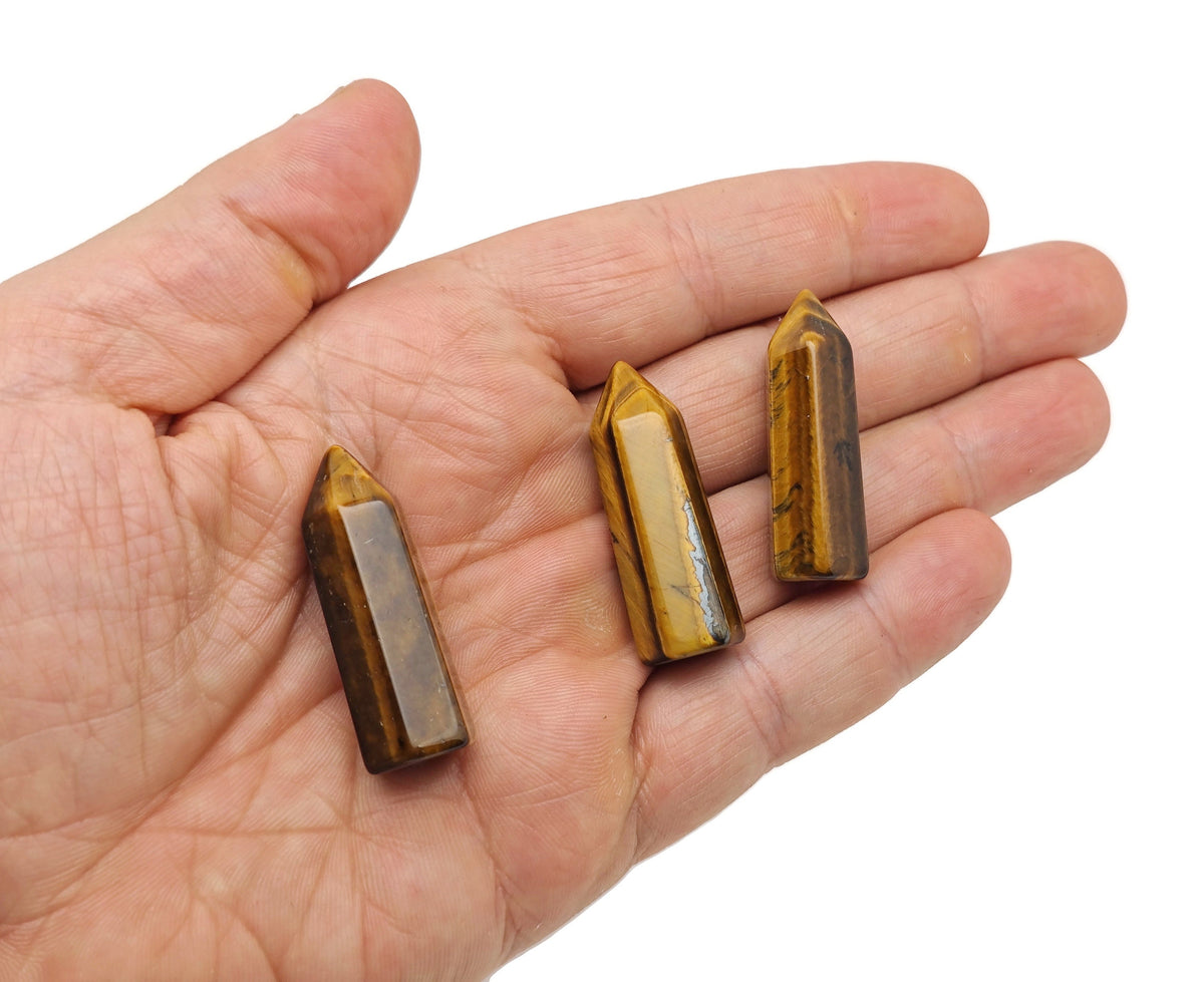 Tiger Eye obelisk tower crystal, 40mm, from GemstoneGO, showing a polished, golden-brown gemstone with distinctive banding and smooth surface.