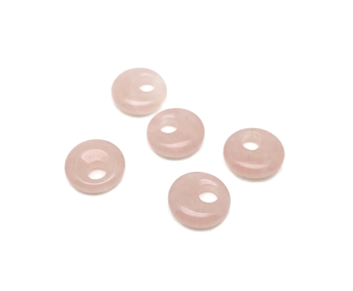 Pink rose quartz crystal donut pendant, 18mm Pi stone from GemstoneGO, showcasing smooth, polished gemstone with a hole in the center.