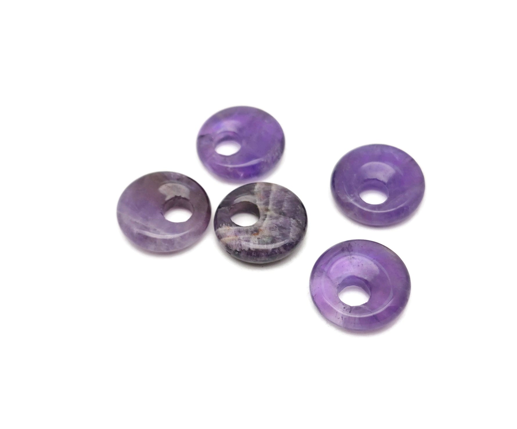 Amethyst crystal donut pendant from GemstoneGO, 18mm Pi stone with purple amethyst gemstone and polished, rounded shape.
