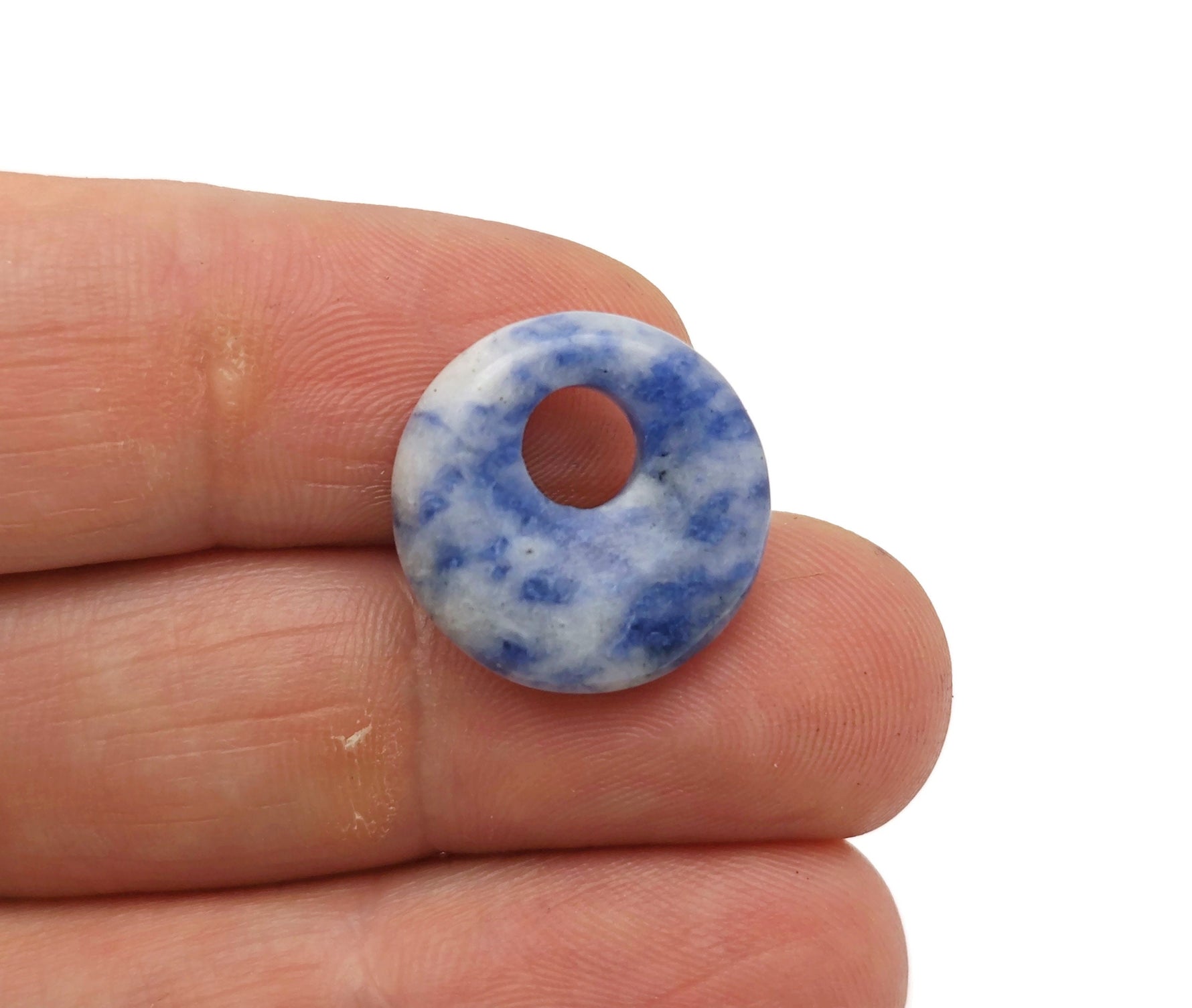 Blue sodalite crystal donut pendant, 18mm Pi stone from GemstoneGO, showcasing polished sodalite with natural veining and a central hole.