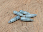 Polished Labradorite Bullet Gemstone Pendant from GemstoneGO, carved into a smooth bullet shape with iridescent flashes.