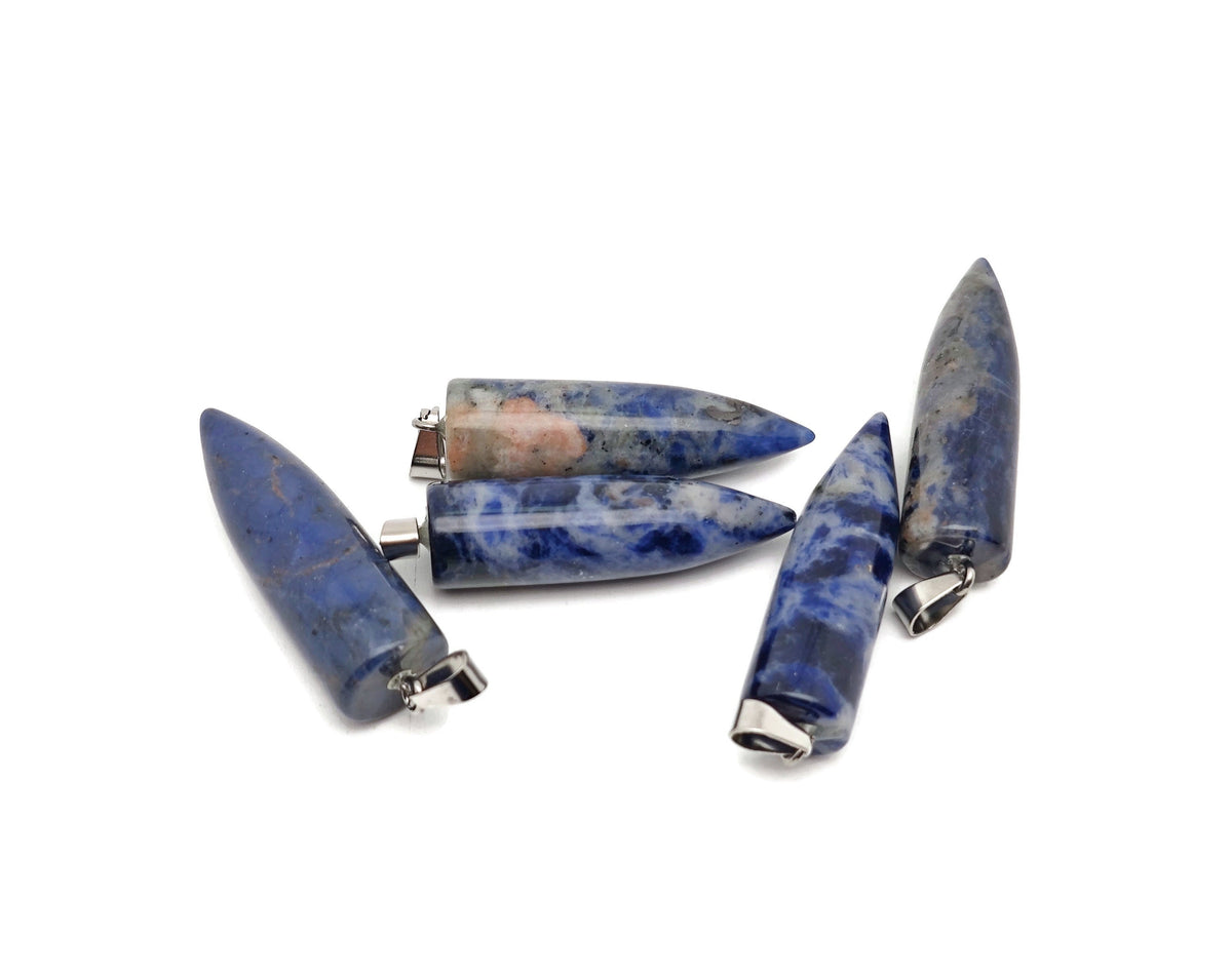 Polished sodalite bullet gemstone pendant with carved details, showcasing deep blue and white natural stone patterns.