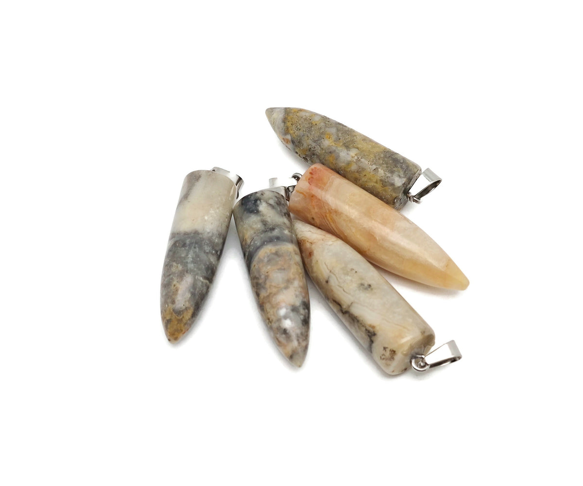 Polished Crazy Lace Agate bullet gemstone pendant with carved details, showcasing vibrant patterns and natural stone texture.