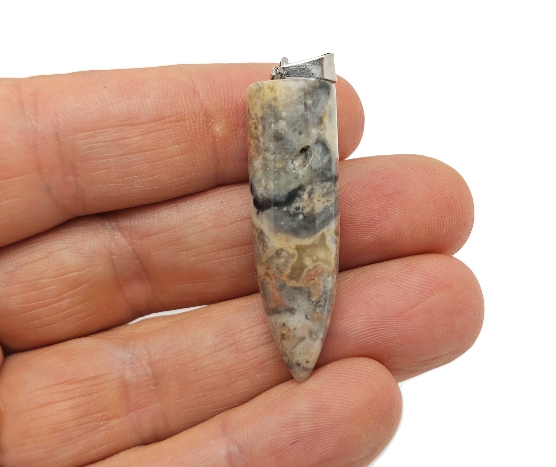 Polished Crazy Lace Agate bullet gemstone pendant with carved details, showcasing vibrant banding and natural stone texture.
