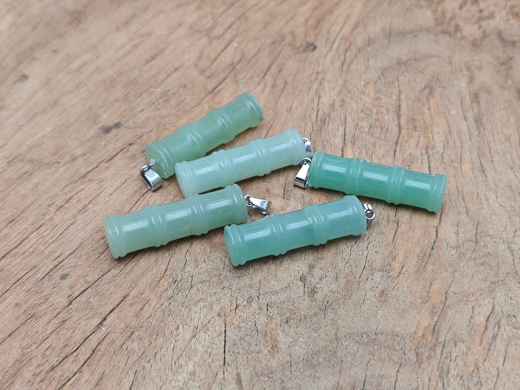 Aventurine bamboo-shaped crystal pendant from GemstoneGO with protective crystal design on a silver chain.