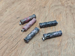 Rhodonite bamboo-shaped crystal pendant with protective energy, featuring vibrant pink and black stone details on a silver chain.