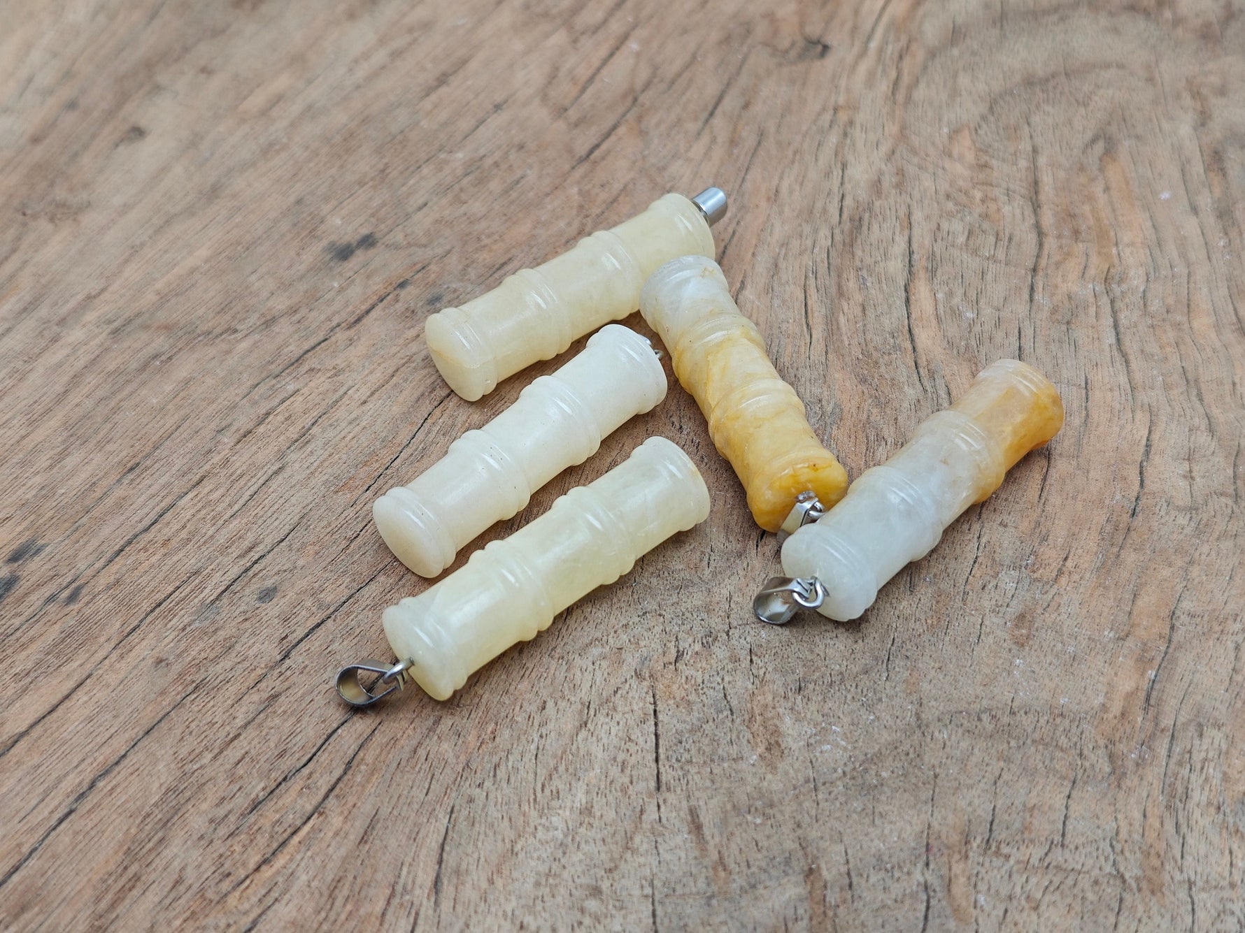 Yellow jade bamboo-shaped crystal pendant from GemstoneGO featuring protective crystal design on a string.