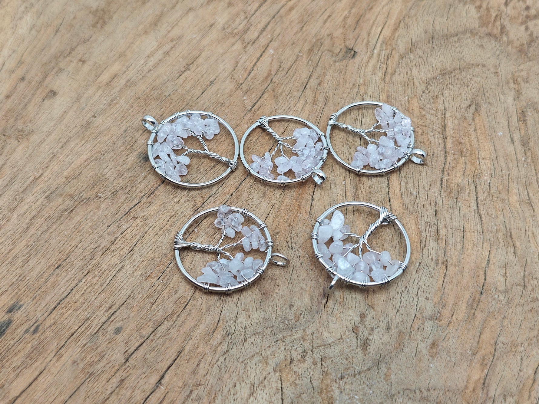 Rose quartz Tree of Life gemstone pendant from GemstoneGO, featuring a detailed crystal tree design on a polished rose quartz base.