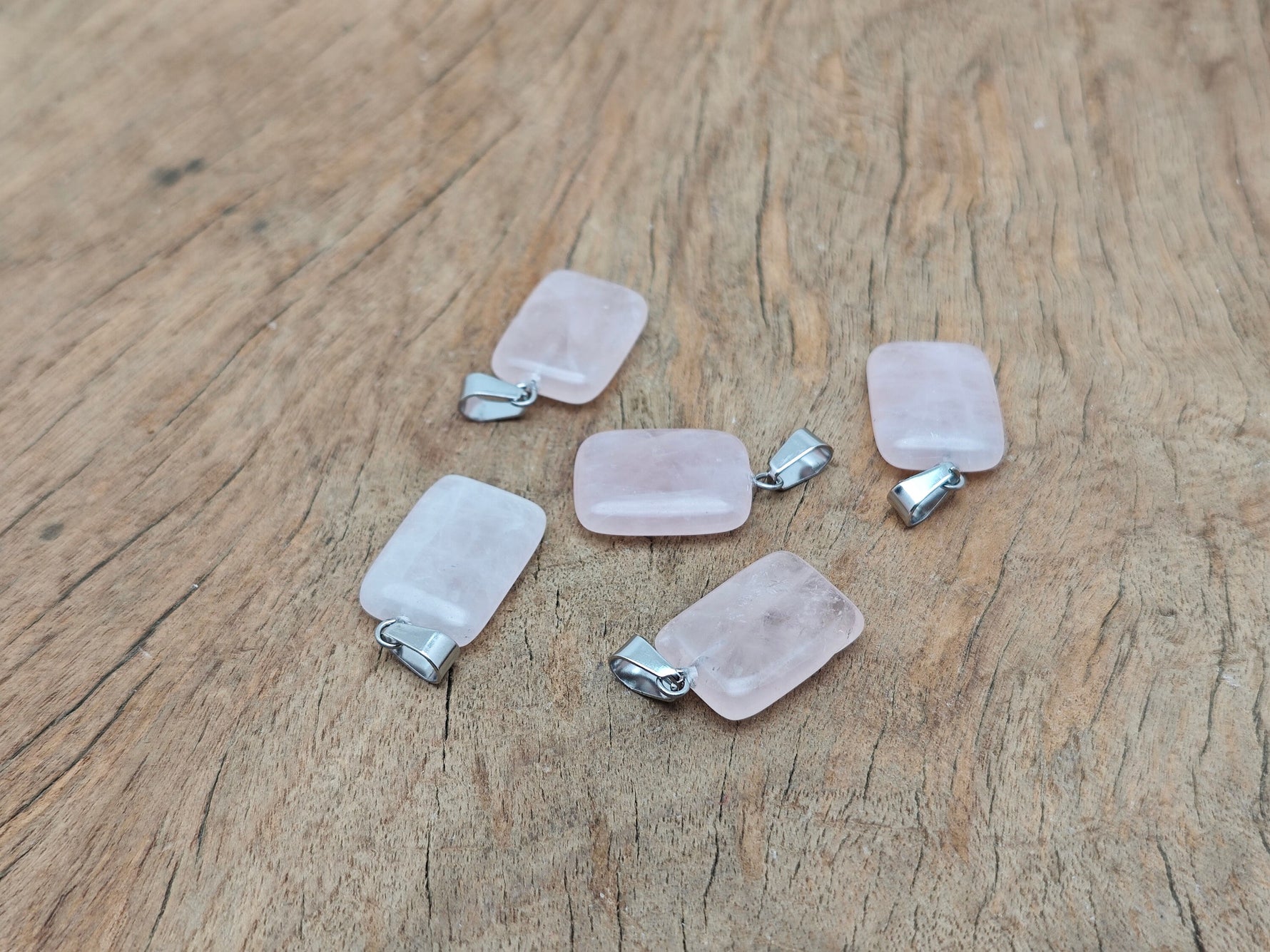 Rose quartz rectangle-shaped crystal pendant from GemstoneGO, showcasing a polished pink gemstone pendant on a silver chain.
