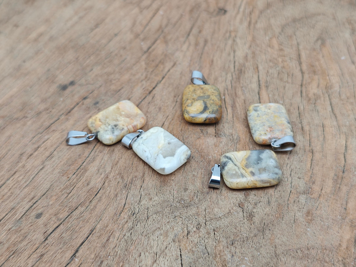 Rectangle-shaped Crazy Lace Agate crystal pendant from GemstoneGO, showcasing vibrant banded patterns on a silver setting.