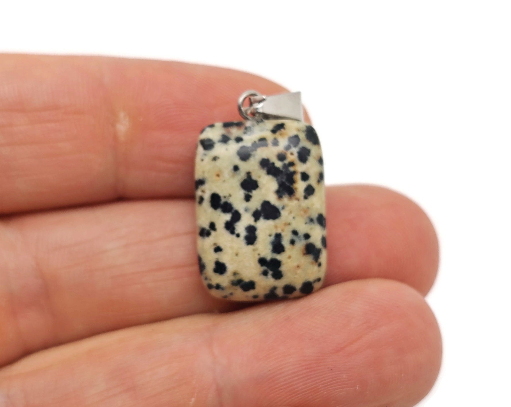 Dalmatian Jasper crystal pendant in a rectangular shape featuring black spots on a beige background, gemstone jewelry by GemstoneGO.