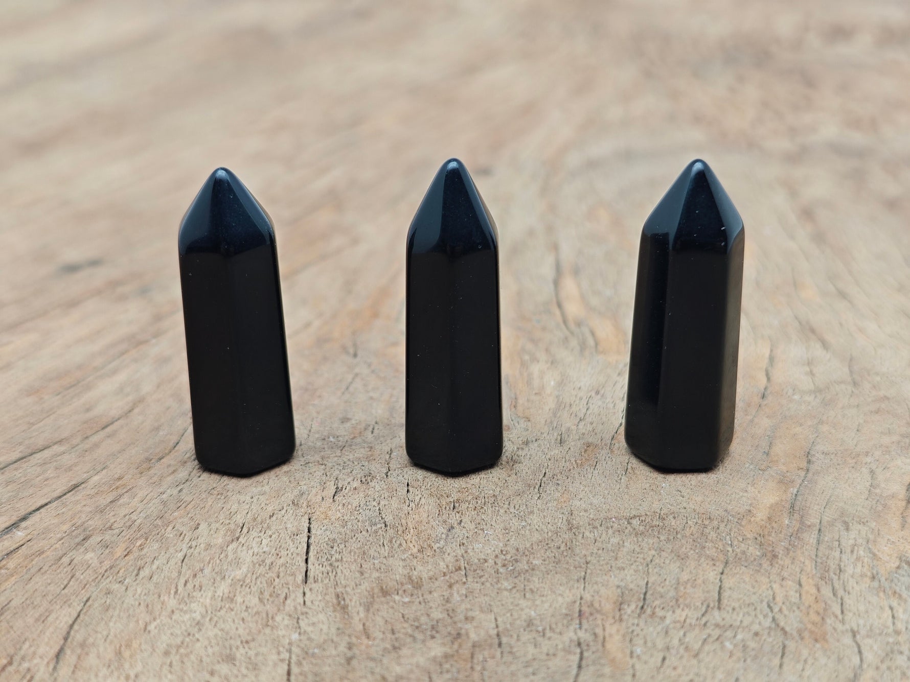 Obsidian obelisk tower crystal, 40mm, from GemstoneGO, featuring a sleek black polished stone with natural crystal details.