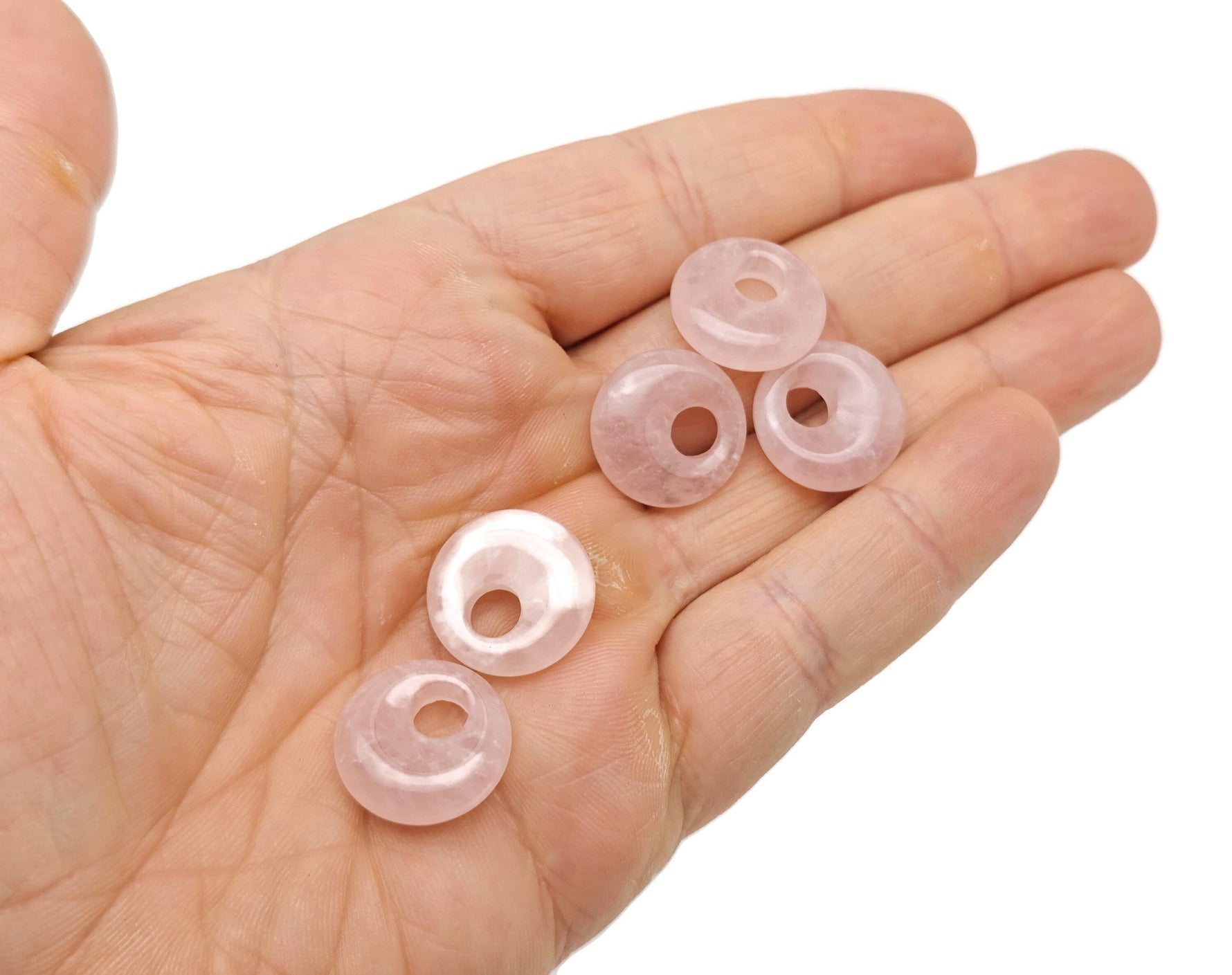 Pink rose quartz crystal donut pendant from GemstoneGO, 18mm Pi stone with smooth polished surface and natural gemstone detailing.