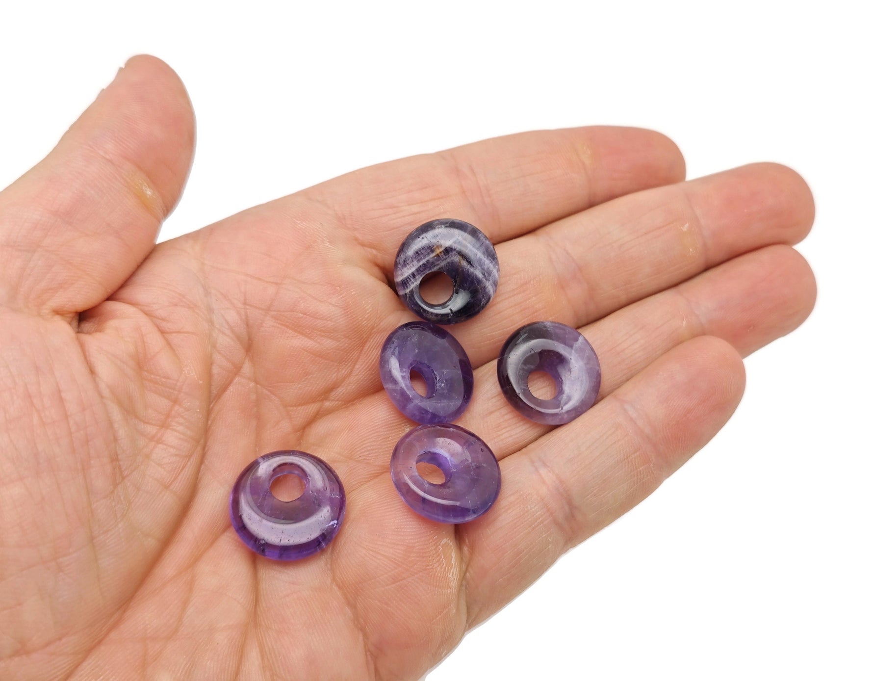 Amethyst crystal donut pendant from GemstoneGO, 18mm Pi stone with purple amethyst gemstone and polished surface.