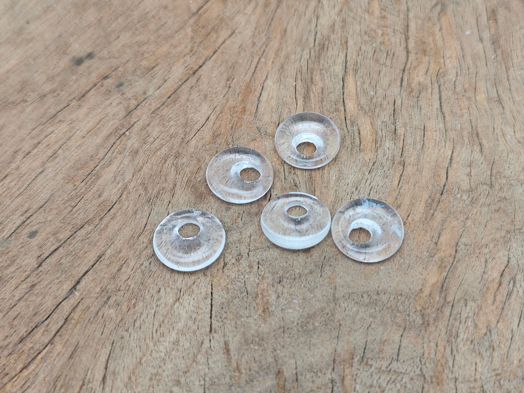 Clear quartz crystal donut pendant, 18mm Pi stone by GemstoneGO, showcasing a polished, transparent gemstone with a smooth, rounded shape.