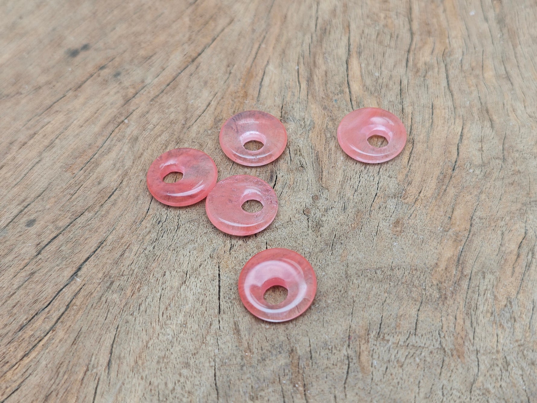 Cherry quartz crystal donut pendant from GemstoneGO, 18mm Pi stone with vibrant red color and smooth, polished surface.