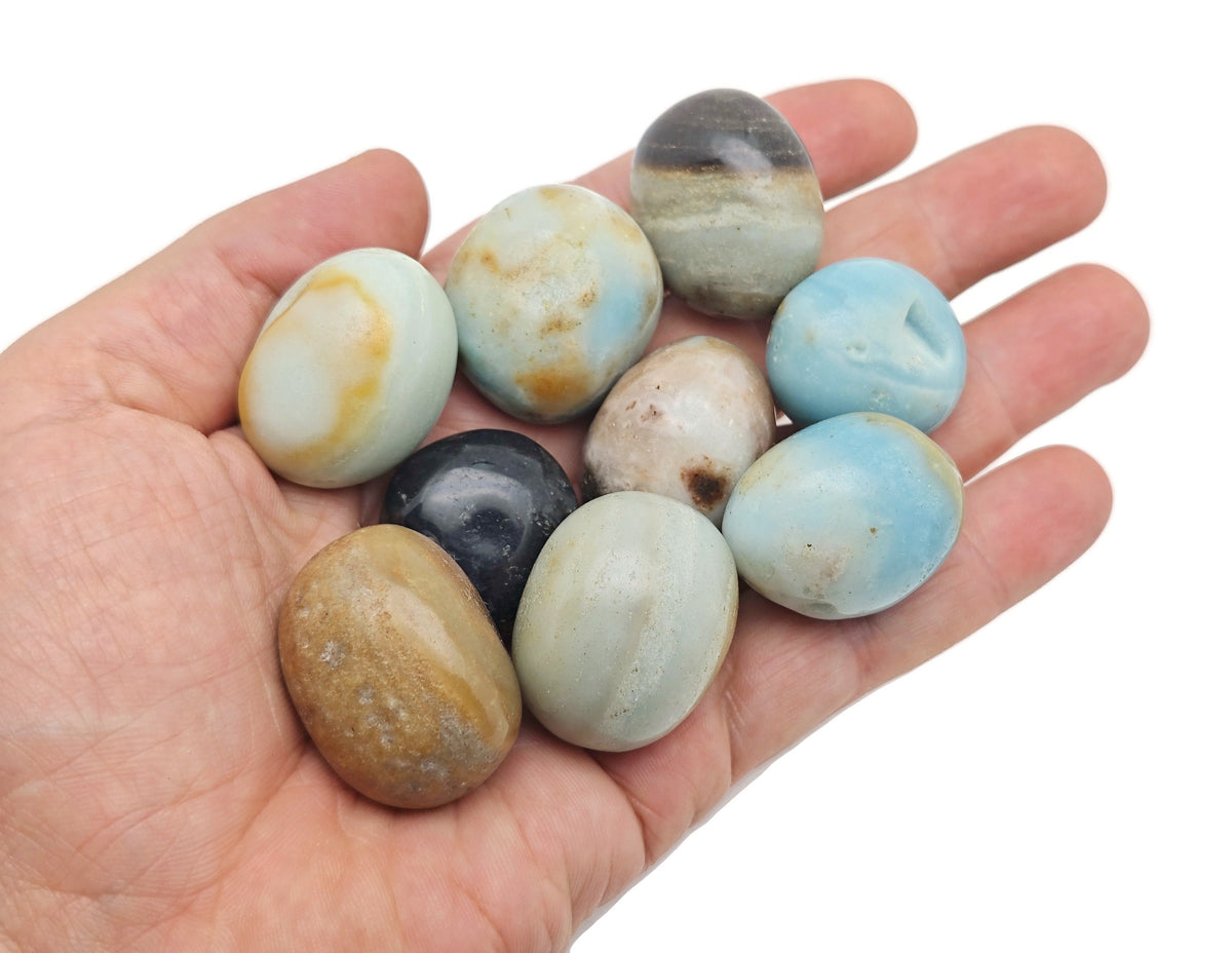 Caribbean Calcite tumbled stone from GemstoneGO showing smooth, rounded orange and white mineral with natural surface details.