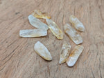 Citrine drilled tumbled gemstone pendant from GemstoneGO, showcasing a vibrant orange-yellow polished stone on a simple string.