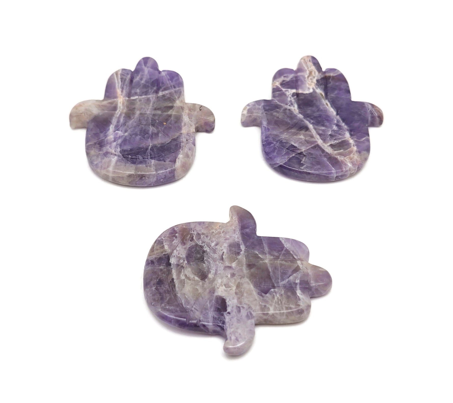 Amethyst evil eye hand gemstone carving with intricate details, showcasing vibrant purple amethyst and protective symbolism.
