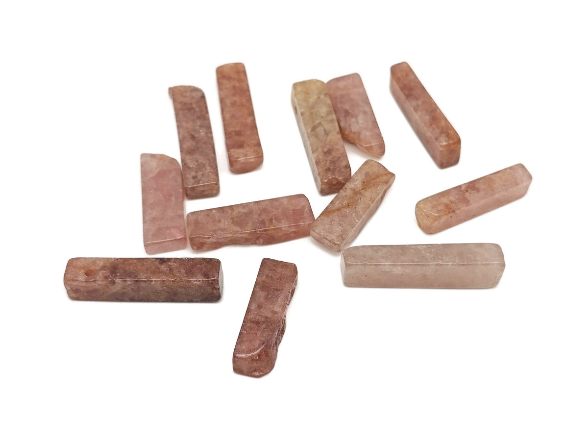 Strawberry Quartz drilled tumbled gemstone pendant from GemstoneGO, showcasing a smooth, polished pink stone with a hole for jewelry.