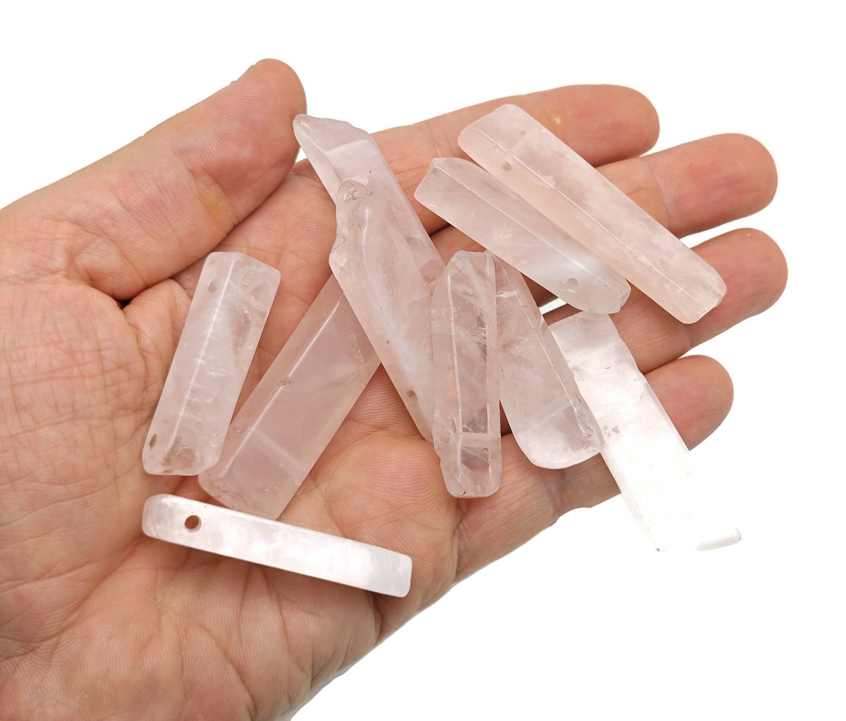 Rose quartz tumbled gemstone pendant with drilled hole, showcasing a smooth, pink, polished gemstone from GemstoneGO.