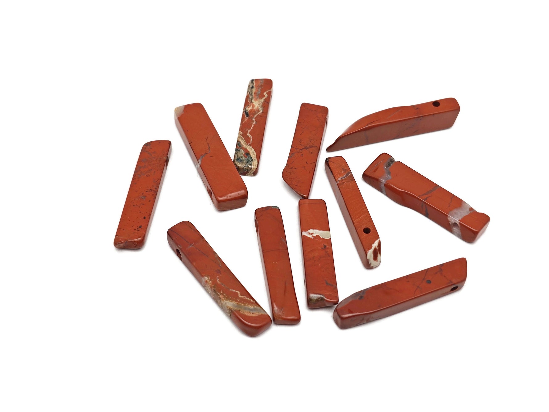 Red Jasper tumbled gemstone pendant from GemstoneGO featuring a drilled, polished red jasper stone on a natural setting.