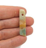 Caribbean calcite drilled tumbled gemstone pendant from GemstoneGO, showcasing vibrant orange and yellow hues with a smooth, polished finish.