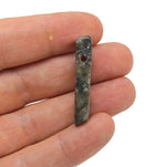 Labradorite drilled tumbled gemstone pendant from GemstoneGO, showcasing iridescent blue and green flashes on smooth, polished stone.