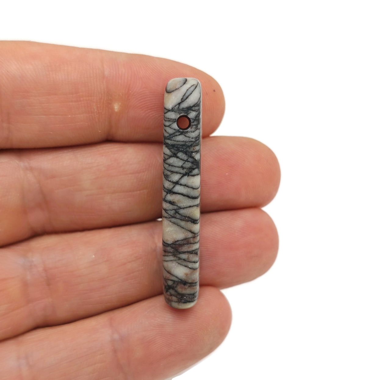 Black network Jasper drilled tumbled gemstone pendant from GemstoneGO, showcasing a polished, natural stone with drilled hole for jewelry.