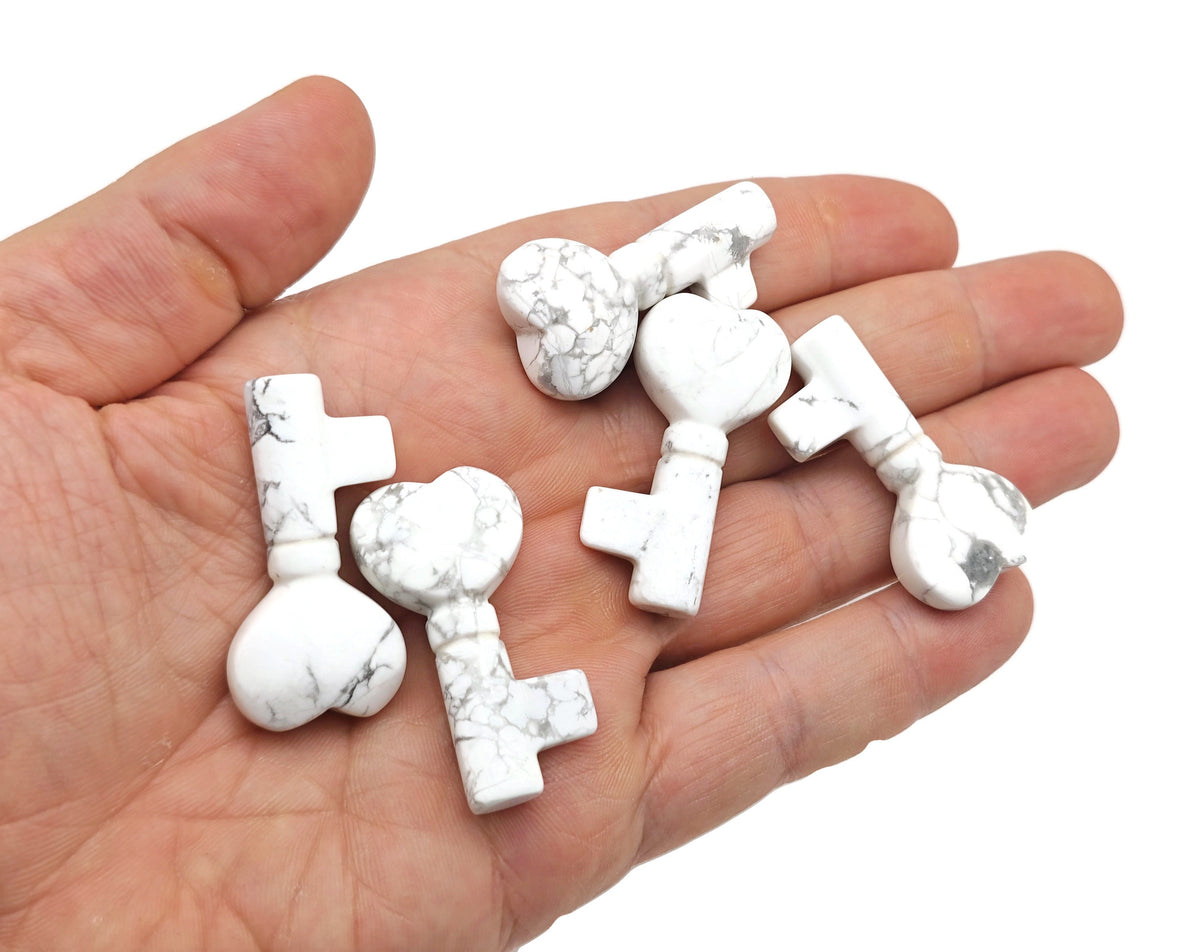 Howlite gemstone key carving, 40mm, from GemstoneGO, featuring polished white stone with gray veining and detailed carving design.