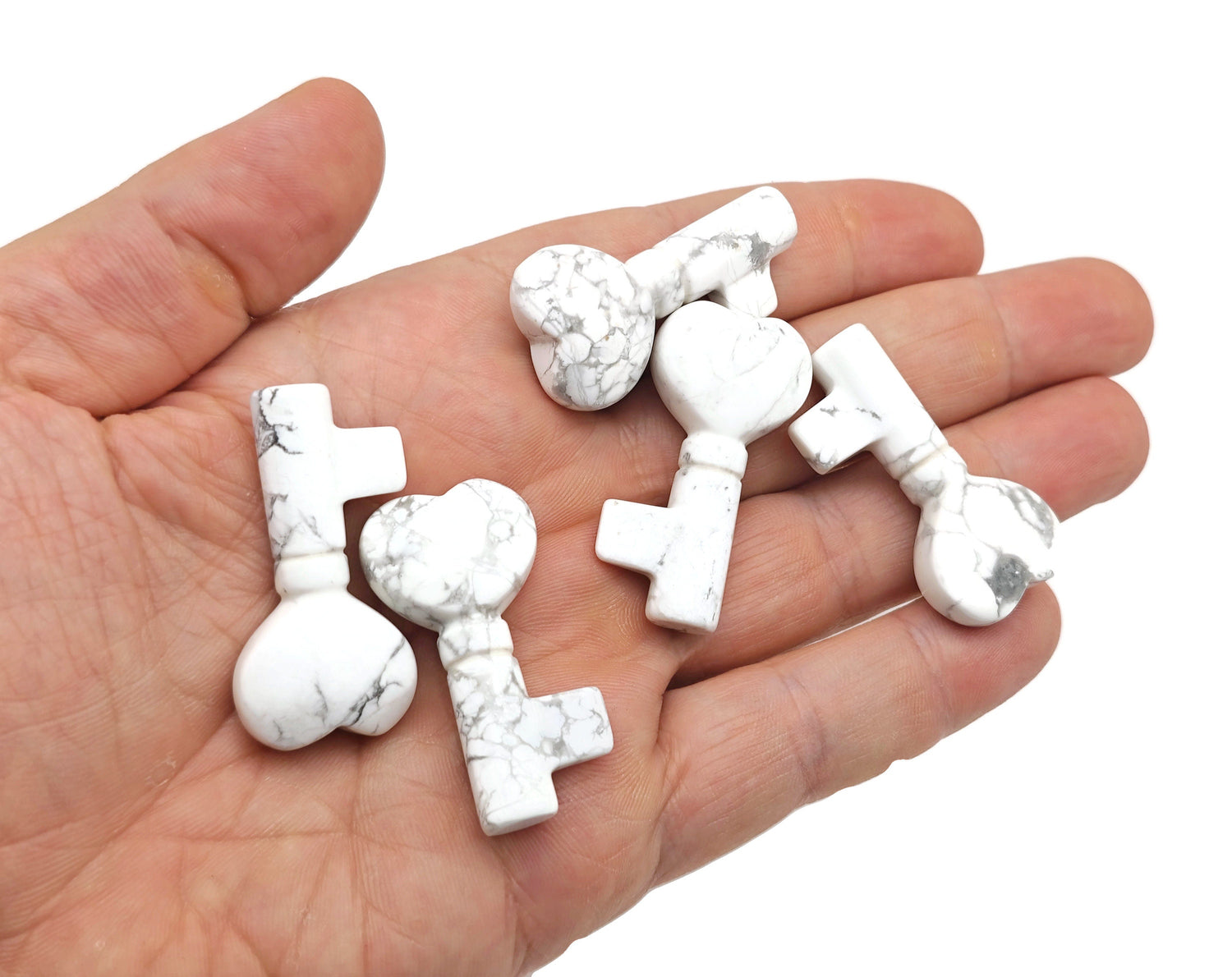 Howlite gemstone key carving, 40mm, from GemstoneGO, featuring polished white stone with gray veining and detailed carving design.