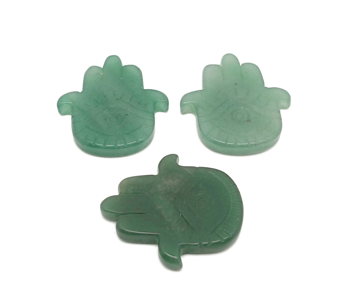 Aventurine evil eye gemstone carving held in hand, featuring intricate hand-carved evil eye design by GemstoneGO.
