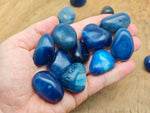 Blue Agate tumbled stone from GemstoneGO showing smooth, polished blue agate with natural banding and vibrant coloration.