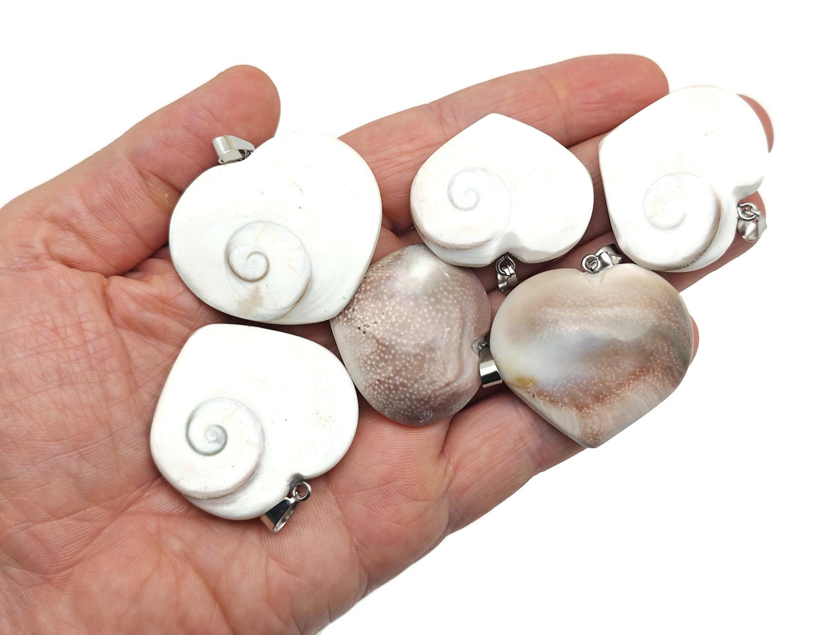 Shiva shell heart pendant with gemstone, featuring a polished gemstone and intricate shell design, hanging on a silver chain.